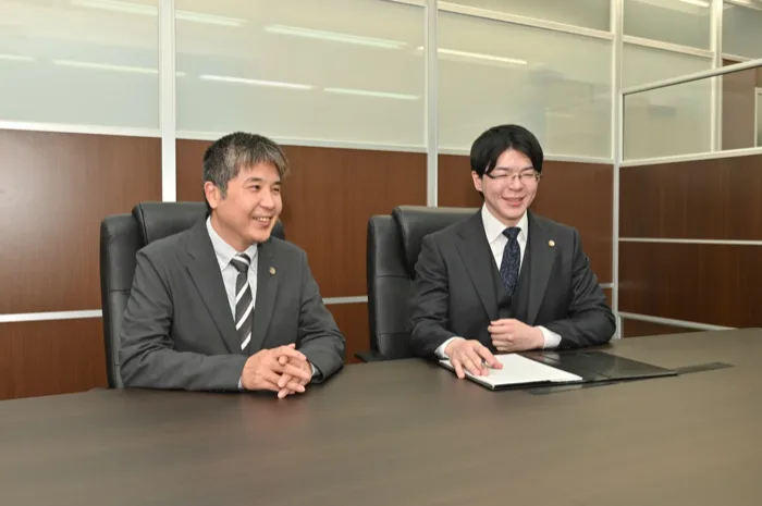 会議室で交通事故の相談に対応する当事務所の弁護士2名