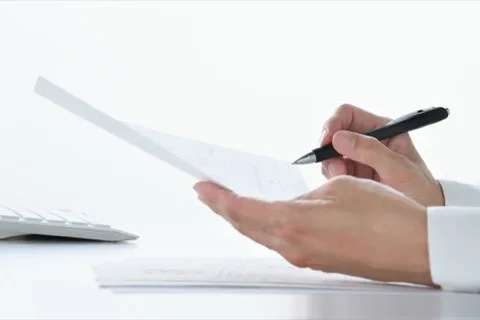 交通事故で使える弁護士費用特約を保険の書類で確認する手元